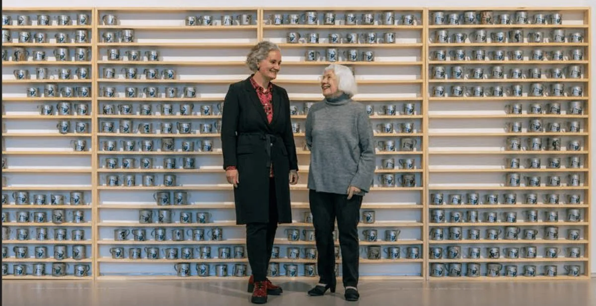 Twee vrouwen staan voor een wand met honderden museumobjecten in vitrinekasten.